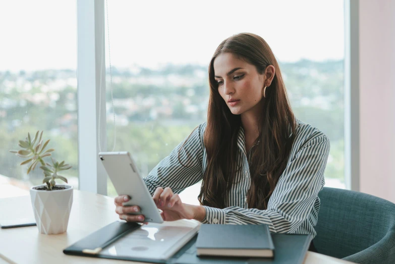 a woman sitting at a table using a tablet computer, a portrait, trending on pexels, female in office dress, pokimane, a handsome, thumbnail