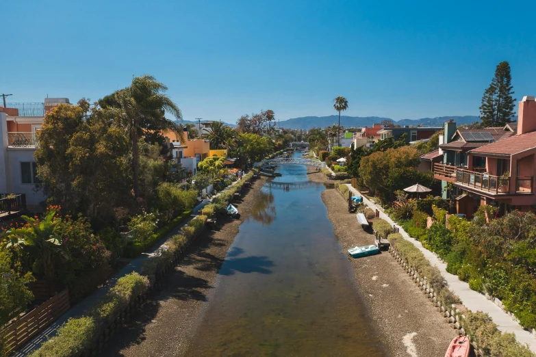 a river running through a lush green forest filled with trees, a digital rendering, by Carey Morris, unsplash contest winner, the city of santa barbara, waterfront houses, canal, a photo of a lake on a sunny day
