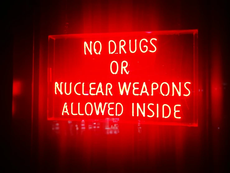 a neon sign that says no drugs or nuclear weapons allowed inside, by Douglas Shuler, 💋 💄 👠 👗, weapons arrays, from wheaton illinois, blood aura red light