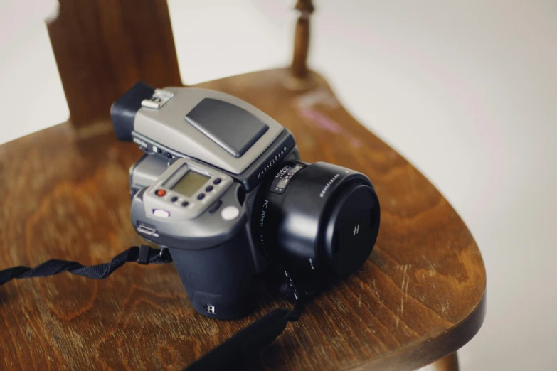 a camera sitting on top of a wooden table, by Romain brook, unsplash, photorealism, hasselblad 500c, overexposed flash, grey, soft light.4k