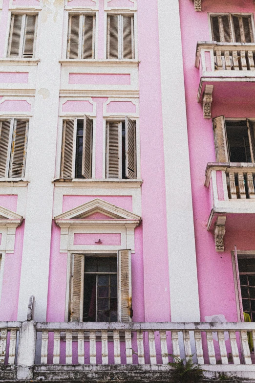 a pink and white building with balconies and balconies, a photo, pexels contest winner, neoclassicism, somalia, dayglo pink, vintage vibe, preserved historical