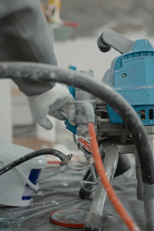 a close up of a person using a machine, by Julian Allen, arbeitsrat für kunst, blue and gray colors, professional paint job, hoses, electrical appendages