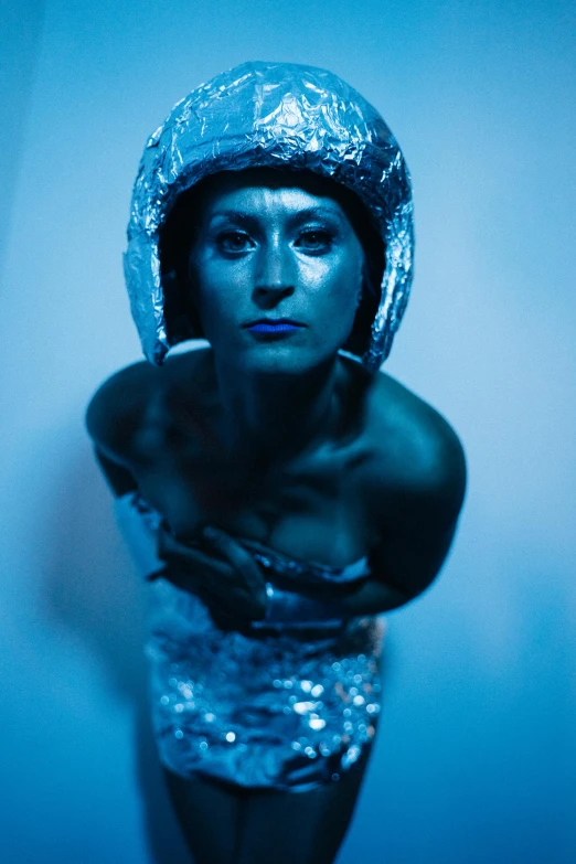 a woman dressed in silver posing for a picture, inspired by hajime sorayama, unsplash, holography, blue metal, dramatic ”, an alien musician lost in space, head piece