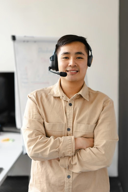 a man wearing a headset standing in front of a whiteboard, half asian, non-binary, background image, maintenance