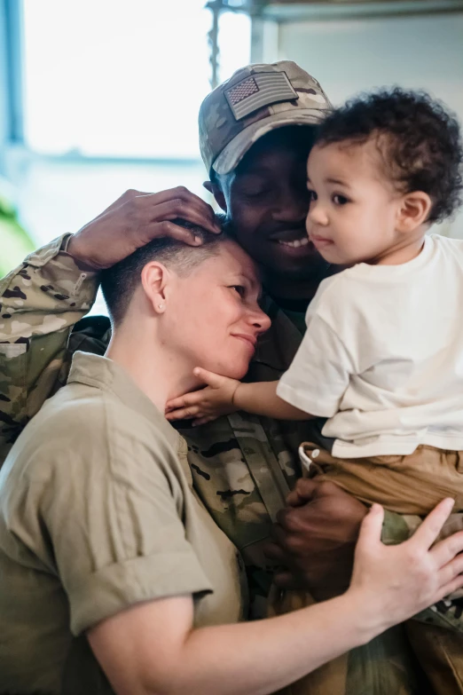 a soldier holding a small child in his arms, by Alison Geissler, trending on unsplash, two men hugging, woman holding another woman, slide show, diverse