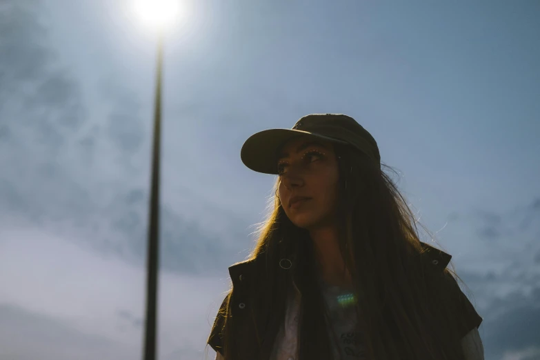 a woman standing in front of a street light, unsplash contest winner, realism, wearing baseball cap, low angle facing sky, 🤤 girl portrait, flares anamorphic