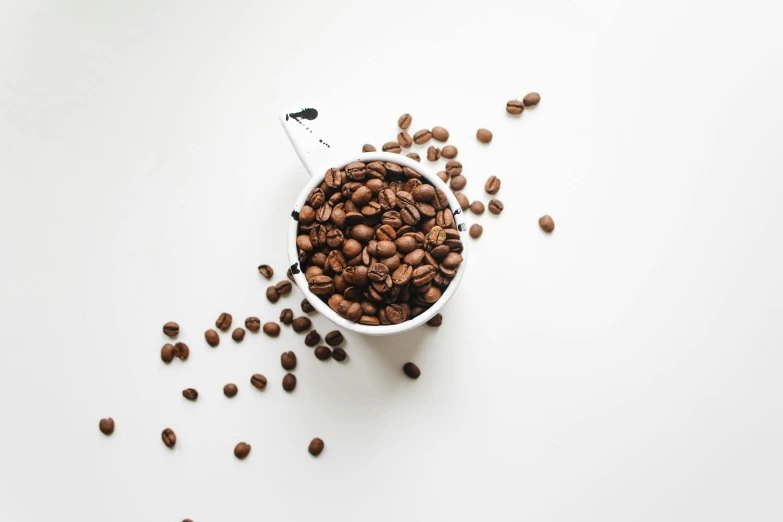 a cup filled with coffee beans on top of a white table, pexels contest winner, fan favorite, avatar image, multiple stories, unedited