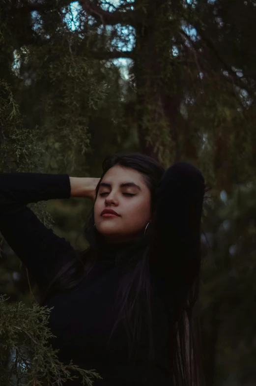 a woman leaning against a tree with her hands on her head, pexels contest winner, aestheticism, still from a music video, julia fuentes, moody aesthetic, girl with black hair