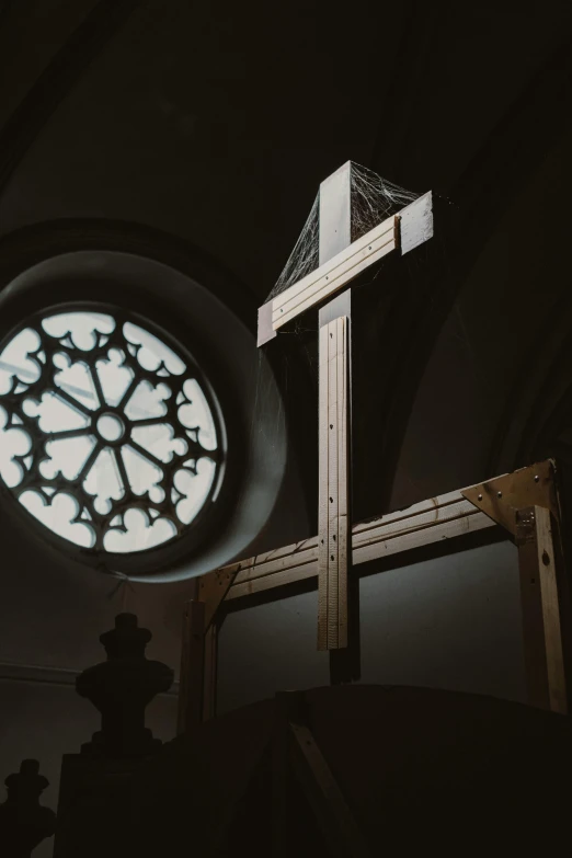 a cross and a window in a church, unsplash, intricate ornament halo, ray lighting from top of frame, on