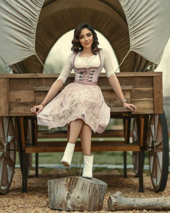 a woman sitting in front of a covered wagon, an album cover, trending on pexels, renaissance, corsets, isabela moner, octoberfest, fullbody photo