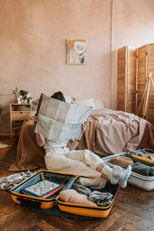 a person laying on the floor with their luggage, by Julia Pishtar, pexels contest winner, maximalism, studyng in bedroom, cardboards ; mess, tending on pinterest, brown and pink color scheme