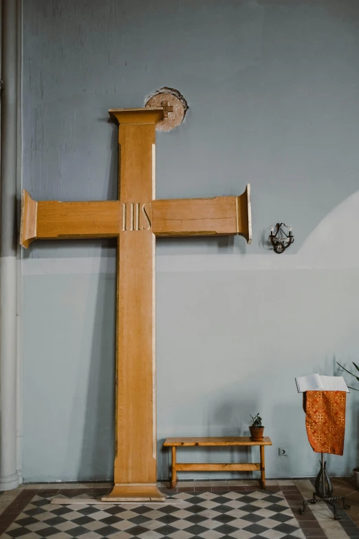 a wooden cross sitting on top of a black and white checkered floor, a picture, by Attila Meszlenyi, unsplash, arts and crafts movement, witness stand, godbeams, ox, hight decorated