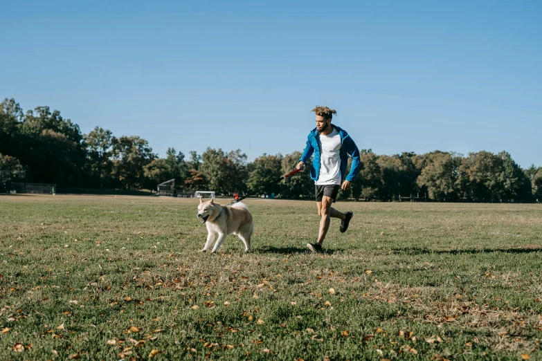 a man running with a dog in a field, by Julia Pishtar, washington dc, sydney park, high quality photo, thumbnail