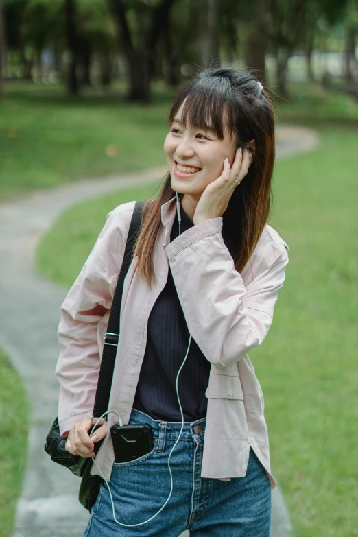 a woman talking on a cell phone in a park, by Tan Ting-pho, pexels contest winner, cropped shirt with jacket, ((pink)), satisfied pose, headset