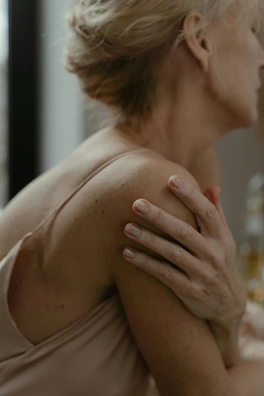 a woman sitting in front of a mirror with her hands on her chest, trending on pexels, renaissance, morning light showing injuries, showing her shoulder from back, cinematic film still, close up of a blonde woman