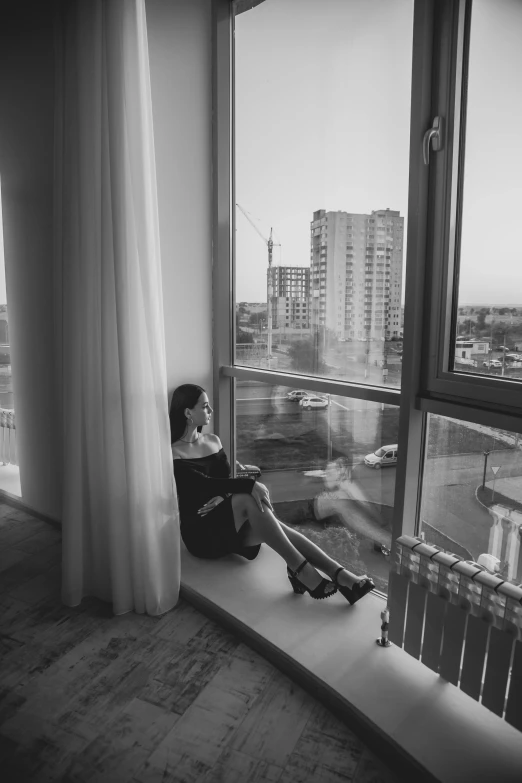 a black and white photo of a woman sitting on a window sill, inspired by Helmut Newton, unsplash contest winner, photography alexey gurylev, view from window on megapolis, spring evening, :: morning