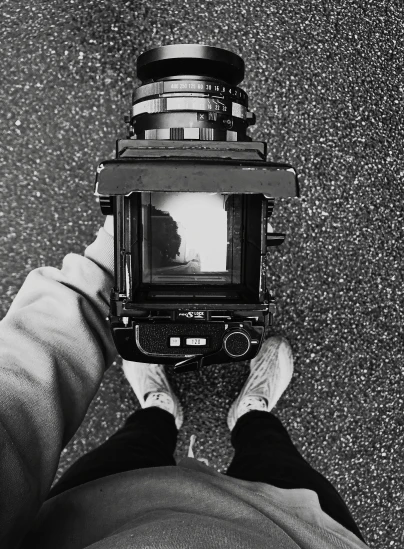 a black and white photo of someone holding a camera, inspired by Vivian Maier, unsplash, art photography, camera on the ground, hasselblad camera, detailed medium format photo, abstract photography