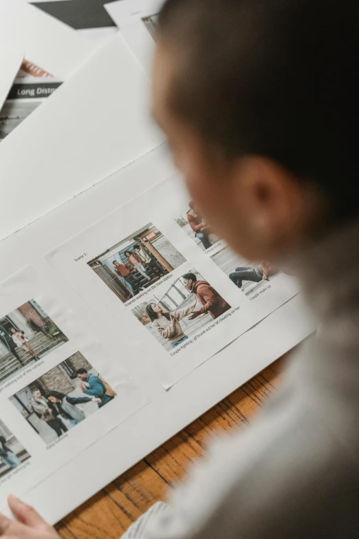 a woman sitting at a table working on a project, a picture, pexels contest winner, printed page, contact sheet, storybook design, up close picture