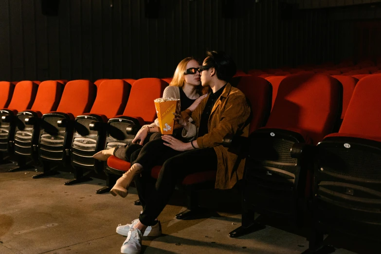 a man and a woman sitting next to each other in a movie theater, a picture, inspired by Nan Goldin, pexels contest winner, romanticism, couple kissing, 3 d film, instagram post, cinematic full body shot