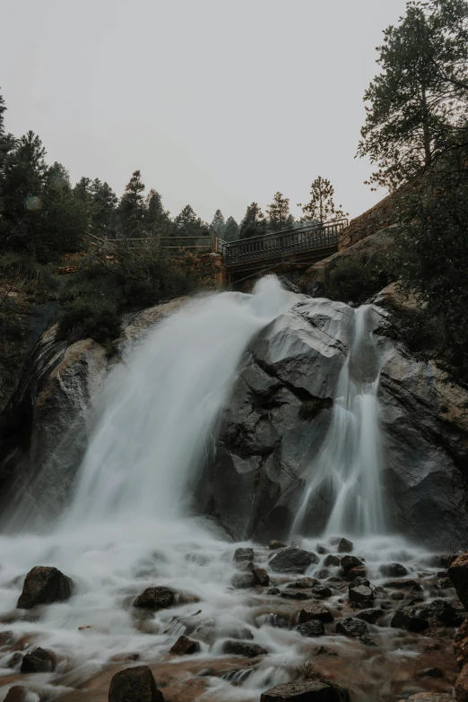 a large waterfall in the middle of a forest, big bear lake california, 2019 trending photo, grey, front side full