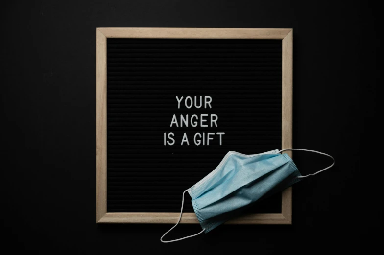 a sign that says your anger is a gift, a picture, inspired by Kaigetsudō Ando, pexels, black facemask, healthcare, instagram picture, angle