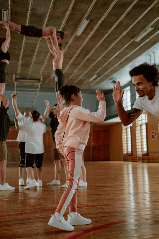 a group of people standing on top of a wooden floor, by Nina Hamnett, pexels contest winner, arabesque, teaching, childish gambino, in australia, ( ( theatrical ) )