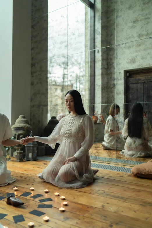 a group of women sitting on top of a wooden floor, an album cover, inspired by Elsa Bleda, pexels contest winner, visual art, two hovering twin nuns, palace ， a girl in hanfu, standing in front of a mirror, [ theatrical ]