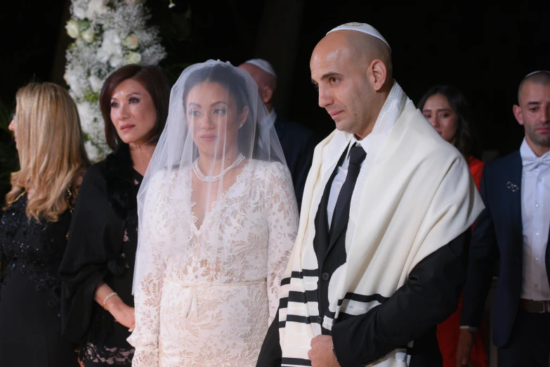 a man and a woman standing next to each other, les nabis, wearing white cloths, ceremony, hana alisa omer, a bald