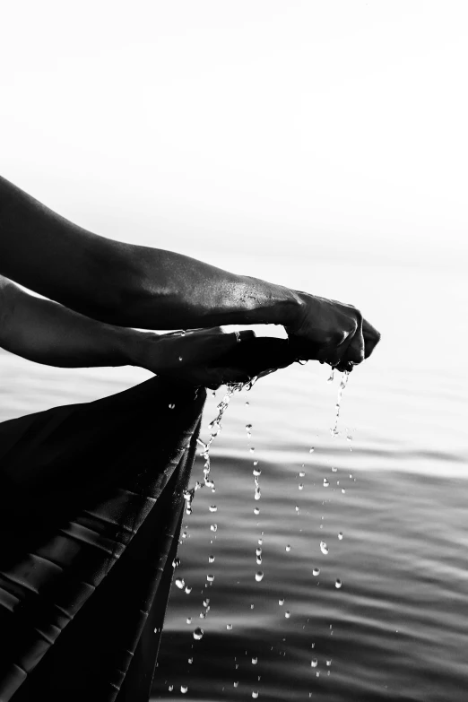 a black and white photo of a person washing their hands, by Daniel Gelon, treading on calm water, harvest, hanging, ariel perez