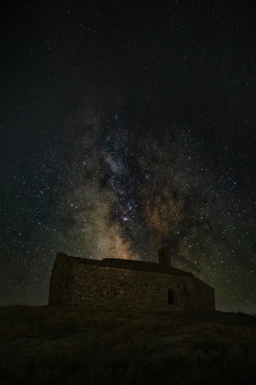 a small building sitting on top of a hill under a night sky, by Ugo Nespolo, jesus alonso iglesias, one galaxy, 2 5 6 x 2 5 6, medium-shot