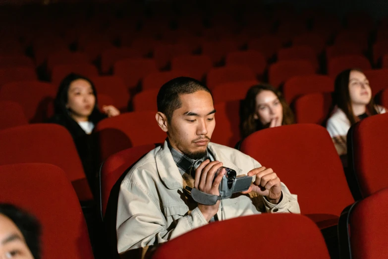 a group of people sitting in a movie theater, a picture, inspired by Fei Danxu, pexels contest winner, hyperrealism, photo of a man, film cam, instagram post, 3 5 mm colour
