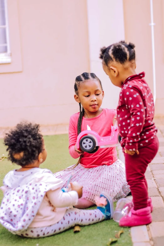 a couple of kids that are sitting on the ground, by Hubert van Ravesteyn, pexels contest winner, at a birthday party, threes, pink, small in size