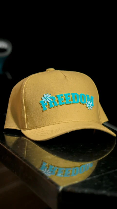 a yellow hat sitting on top of a counter, by Eddie Mendoza, open eye freedom, gold and teal color scheme, official product photo, flowery