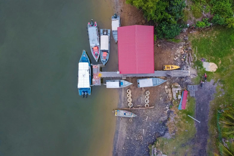 a group of boats sitting on top of a body of water, by Daren Bader, pexels contest winner, hurufiyya, boat dock, avatar image, close-up from above, building along a river