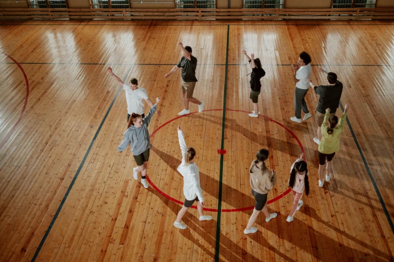 a group of people standing on top of a basketball court, by Nina Hamnett, trending on pexels, interactive art, summoning circle, in the high school gym, choreographed, thumbnail