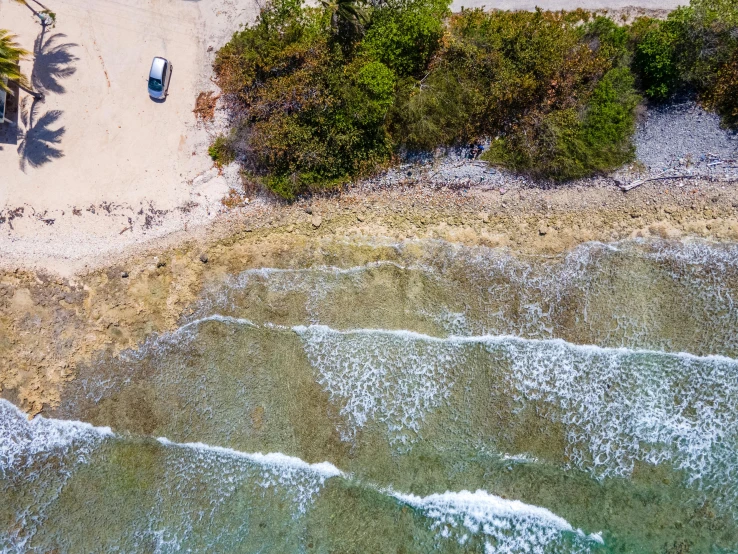 a car parked on top of a sandy beach next to the ocean, pexels contest winner, birdseye view, thumbnail, coral reefs, jamaica