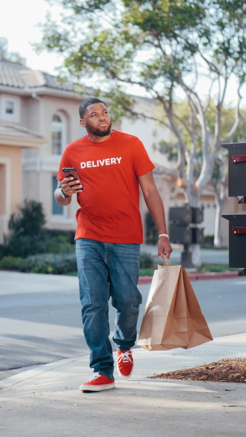 a man in a red shirt is walking down the street, a digital rendering, pexels, logo for lunch delivery, black man, square, plus-sized