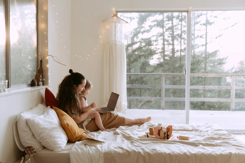 a woman sitting on a bed with a laptop, trending on pexels, woman holding another woman, tiny person watching, natural lights, teenager hangout spot