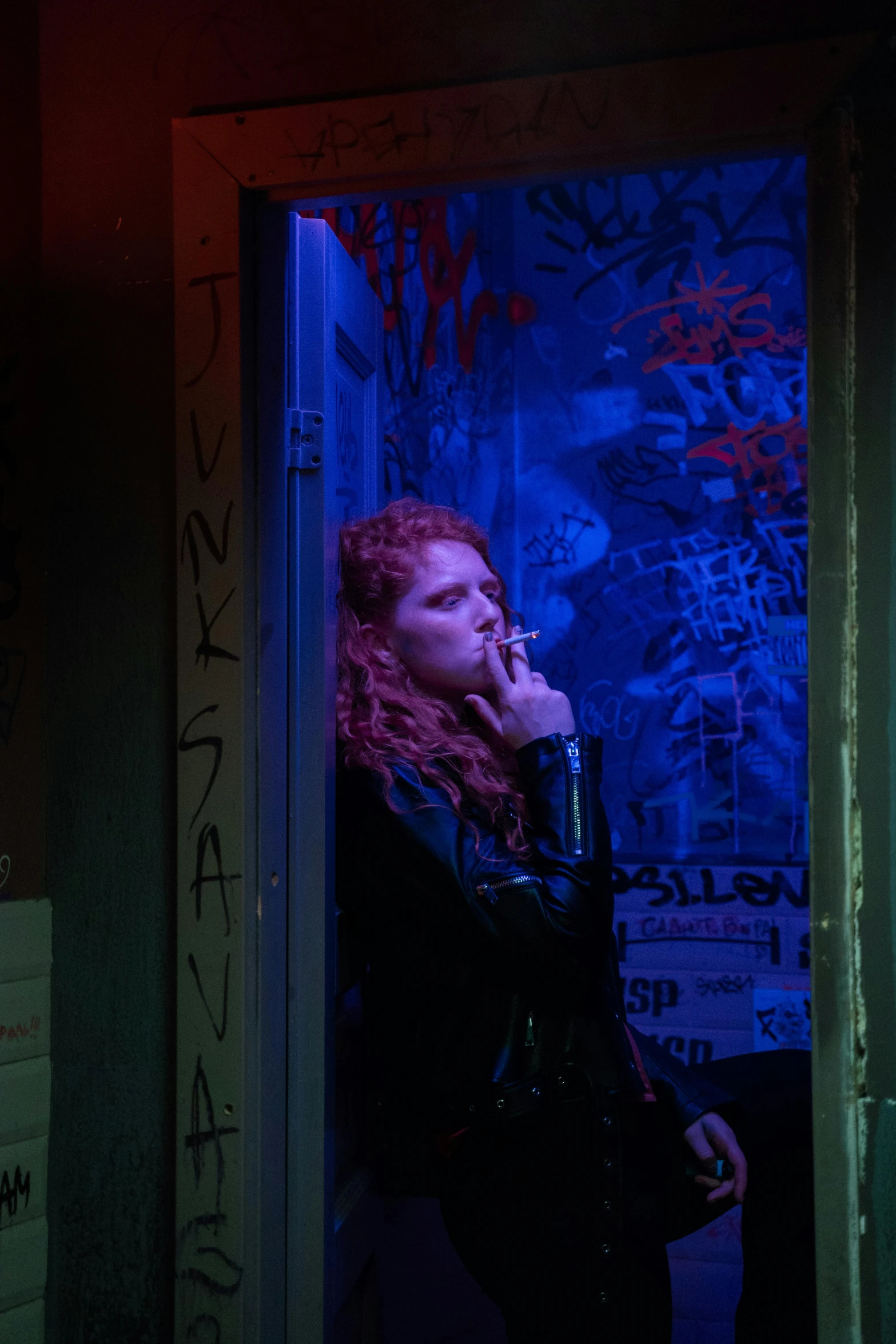 a woman standing in a doorway talking on a cell phone, inspired by Nan Goldin, trending on reddit, renaissance, redhead female cyberpunk, smoking a cigarrette🚬, blacklight aesthetic, picture of a female biker