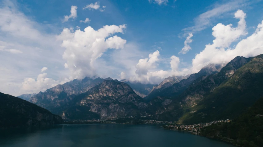 a large body of water surrounded by mountains, by Daniel Lieske, pexels contest winner, vouge italy, boka, thumbnail, skies