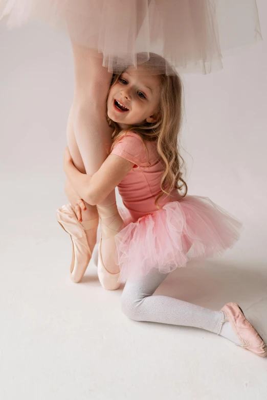 a little girl that is sitting on the ground, pexels contest winner, arabesque, smiling and dancing, studio picture, pink, hugging her knees