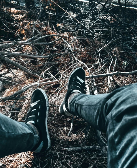 a person sitting on the ground with their feet up, unsplash contest winner, blair witch project, sneaker photo, ((trees)), album cover
