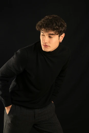 a man standing with his hands in his pockets, an album cover, inspired by John Luke, trending on pexels, black wool sweater, blank background, headshot profile picture, thinker