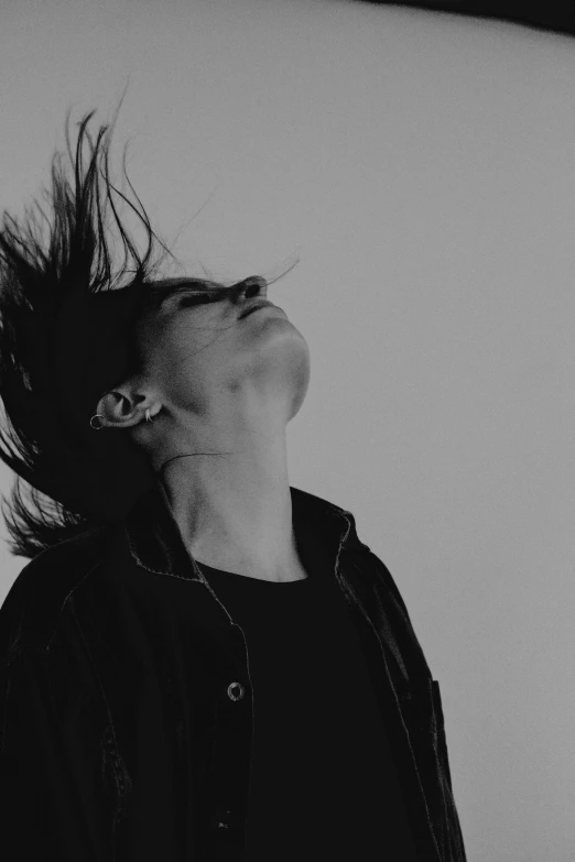 a black and white photo of a woman with her hair in the air, androgynous male, head bowed slightly, uploaded, electrified hair