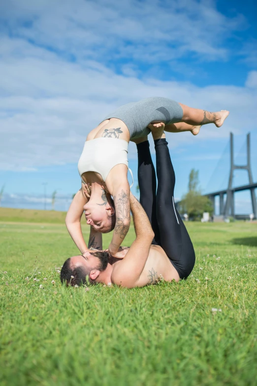 a man and woman doing a handstand in a park, by Nina Hamnett, happening, two muscular men entwined, lynn skordal, square, high-quality photo