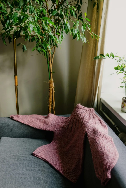 a couch sitting in a living room next to a window, by Else Alfelt, shawl, mermaid tail, faded pink, cropped wide sleeve