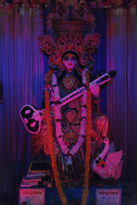 a close up of a statue of a person with a guitar, in a temple, cybertronic hindu temple, ✨🕌🌙, disco club of the occult