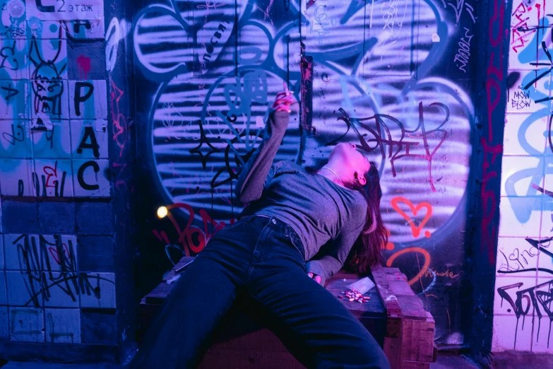 a woman leaning against a wall with graffiti on it, inspired by Nan Goldin, graffiti, purple scene lighting, lying down, an escape room in a small, vfx action shot