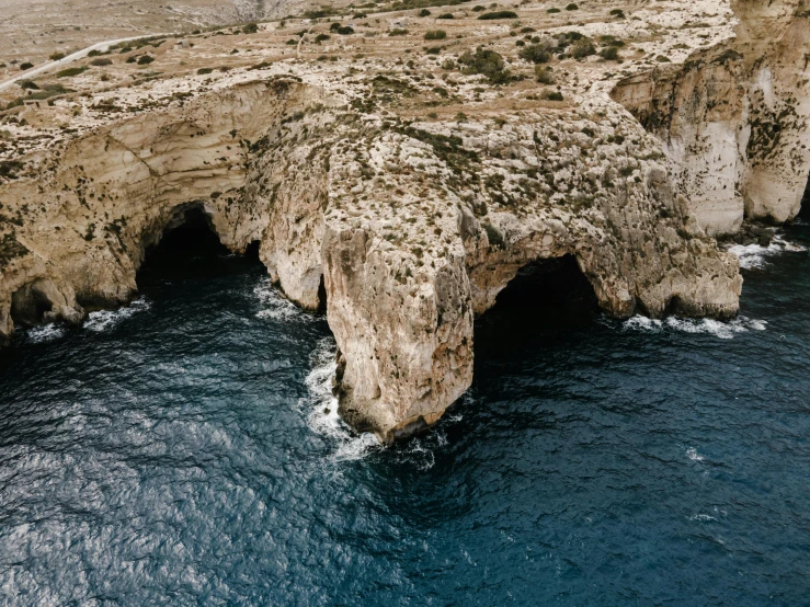 a large rock formation in the middle of the ocean, pexels contest winner, les nabis, white sweeping arches, cyprus, aerial, highly detailded