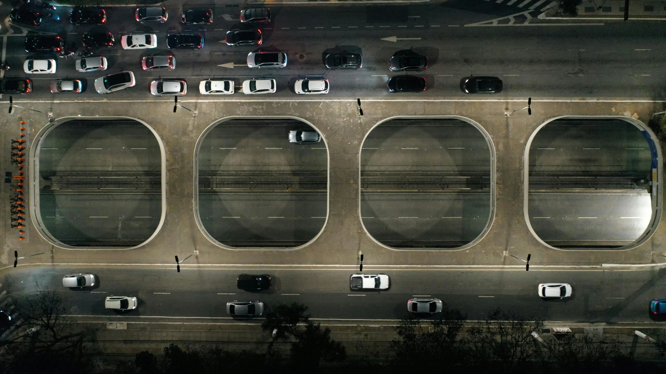 an aerial view of a parking lot at night, an album cover, by Adam Marczyński, conceptual art, overpass, round windows, hyperrealistic n- 4, heavy traffic